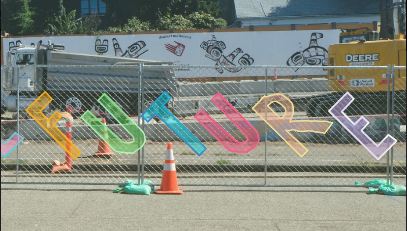A chain link fence at a construction site. The word FUTURE has been graphically added to the front of the fence in large, colorful block lettering